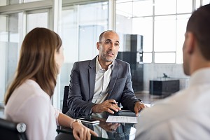 financial advisor speaking with a group of employees at their job