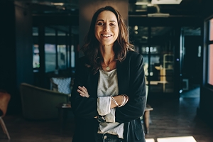 chief executive officer standing proudly in their office