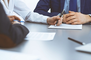 hands signing contracts for an insurance policy