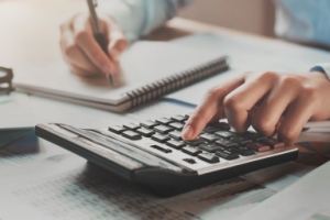 tax accountant reviewing statements on a calculator