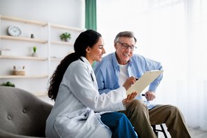 A female doctor showing the benefits of critical illness insurance to a patient