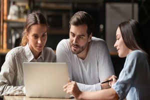 A female insurance agent showing insurance plans to a couple