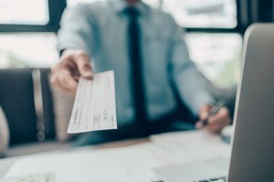 A man in the office giving a check