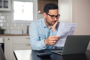 A man reading a life insurance document while sitting on the table