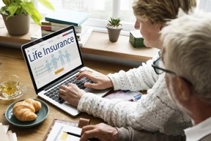 people checking life insurance on laptop