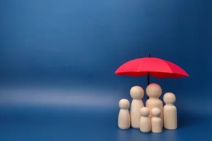 family of wooden dolls are hiding under a red umbrella